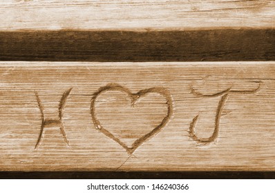 Initials of a love couple, carved in a bench plank
