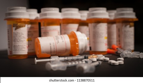 An injectable drug is loaded into a syringe while prescription medication is strewn about haphazardly. 