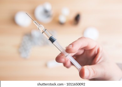 injection close up. person holding a injection over a table with medicament.  vaccine concept.