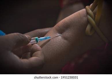 The injection needle has been inserted into the woman's hand