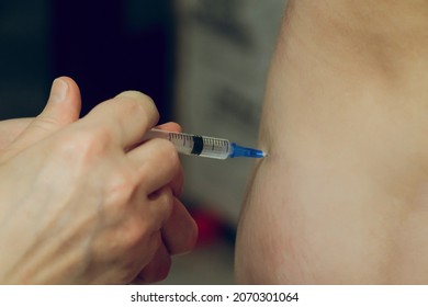 Injection with a syringe into the body. Self-medication at home. Medical disposable syringe with vaccine in hands without gloves.