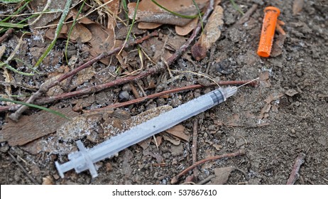 injection syringe and needle of a drug user on the frosted ground