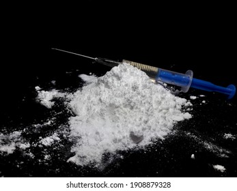 Injection Syringe On Cocaine Drug Powder Pile On Black Background