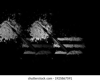 Injection syringe on cocaine drug powder pile and bag on black background