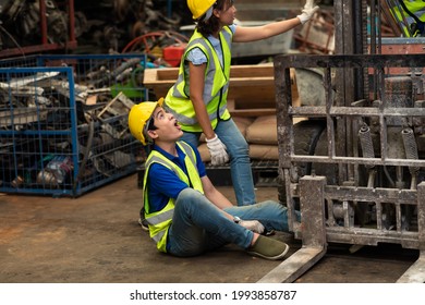 Injured Asian Man Worker After Accident In A Old Car Parts Warehouse.  Forklift Crash Leg Worker Accident