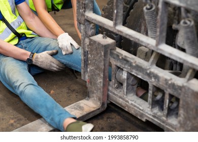 Injured Asian Man Worker After Accident In A Old Car Parts Warehouse.  Forklift Crash Leg Worker Accident