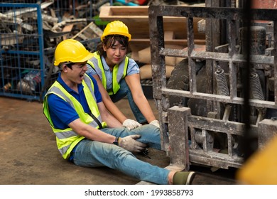 Injured Asian Man Worker After Accident In A Old Car Parts Warehouse.  Forklift Crash Leg Worker Accident