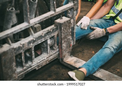 Injured Asian Man Worker After Accident In A Old Car Parts Warehouse.  Forklift Crash Leg Worker Accident