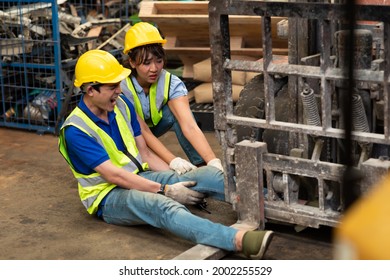 Injured Asian Man Worker After Accident In A Old Car Parts Warehouse.  Forklift Crash Leg Worker Accident