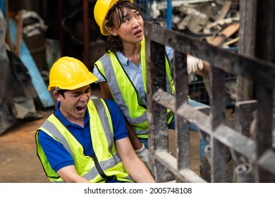 Injured Asian Man Worker After Accident In A Old Car Parts Warehouse.  Forklift Crash Leg Worker Accident