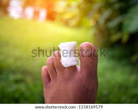 injured big toe with bandage on blur background with sunlight.