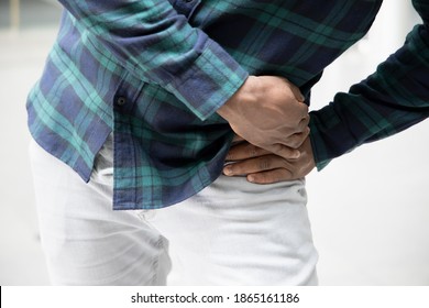 Injured black African man suffering from pelvic pain or hip joint injury