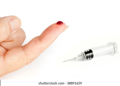 Injured bleeding finger closeup and a blurred syringe in the background