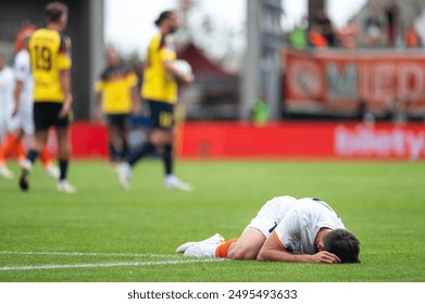 The injured footballer lies on the pitch. - Powered by Shutterstock