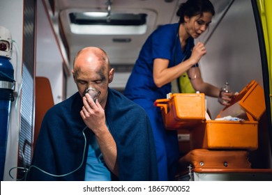 Injured Man In A Blanket Is Getting First Aid In An Ambulance Car.