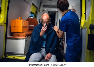 Injured Man In A Blanket Is Getting First Aid In An Ambulance Car.