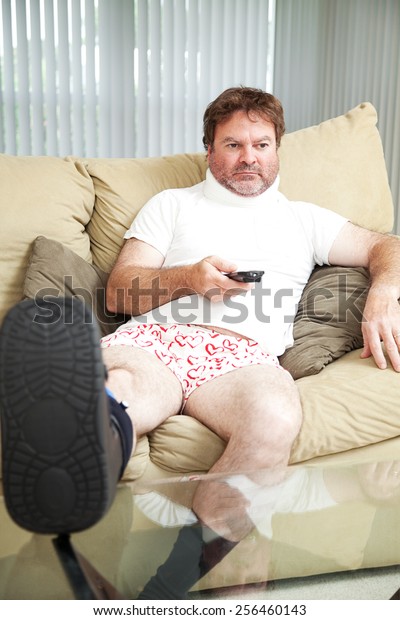Injured man at home on the couch, wearing a foot brace\
and neck collar.  