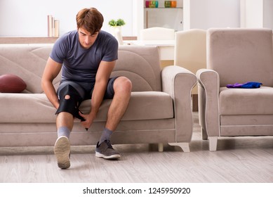 Injured man recovering at home from sports injury - Powered by Shutterstock