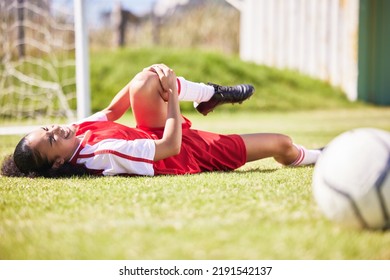 Injured, pain or injury of a female soccer player lying on a field holding her knee during a match. Hurt woman footballer with a painful leg on the ground in agony having a bad day on the pitch - Powered by Shutterstock
