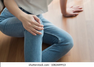 injured woman with broken knee or leg pain; portrait of asian woman falling down, breaking her knee joint, knee bone due to accident, body injury or home accident concept; 30s adult asian woman model
