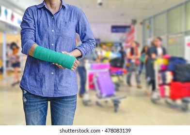Injured woman with green cast on hand and arm on traveler in motion blur in airport interior background, Travel insurance concept.