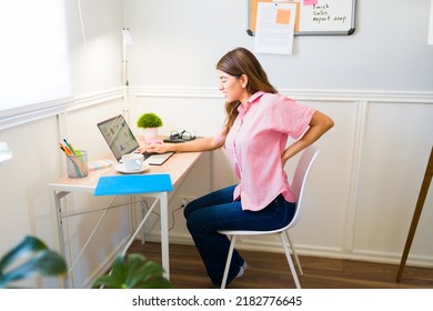 Injured Woman Suffering From Back Pain Because Of Bad Posture While Sitting At Her Office Desk While Working From Home