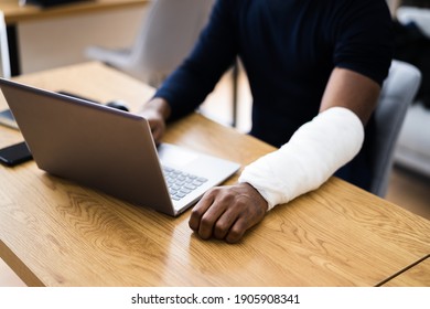 Injured Worker Compensation. Broken Arm African Man On Computer - Shutterstock ID 1905908341