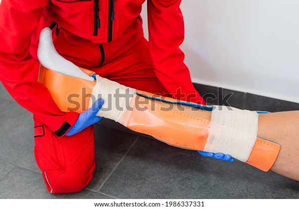 Injury leg. Young man with\
injured leg. Young woman doctor helps the patient. Close - up.\
First aid