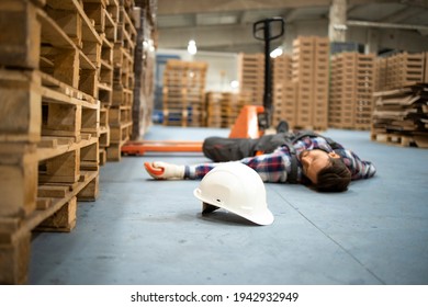 Injury At Work. Warehouse Worker Lying Unconscious On The Concrete Floor After The Fall.