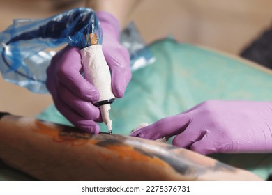 Ink artist making a new tattoo in close up