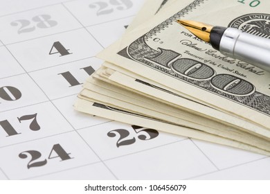 Ink Pen And Dollar Money On Calendar Background