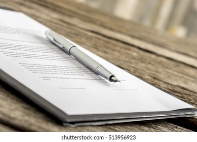 Ink pen lying on a contract or application form, low angle view.