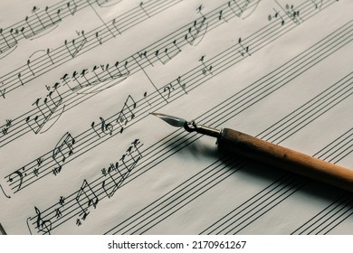 Ink pen on the background of a lined sheet with notes, writing notes, composing music