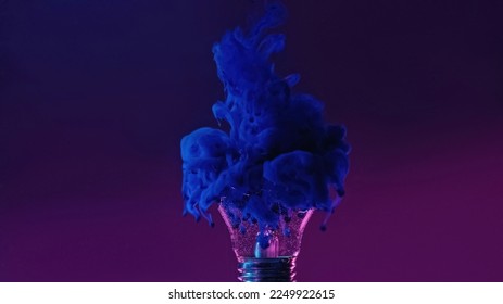 Ink shot in broken lamp. Neon background. Blue color fluid splash smoke cloud filling cracked glass light bulb in water on dark purple abstract copy space. - Powered by Shutterstock