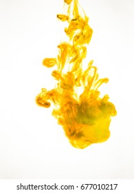 Ink Swirl In Water Isolated On White Background. The Paint In The Water. Soft Dissemination A Droplets Of Colored Ink In Water Close-up. Abstract Background. Explosion Of Splashes Yellow Acrylic Ink.