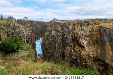 Inland view of Boca do Inferno, or the mouth of Hell chasm located in the seaside cliffs of Cascais, Portugal, in the District of Lisbon, where seawater rushes in and out of a rocky opening.