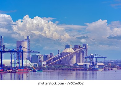 Inland waterway port with tall silos used to store powdered cement located on the bank of a river Long Tau. Vietnam, Southeast Asia