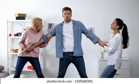 In-law Conflict, Mother And Wife Pulling Young Man In Different Directions