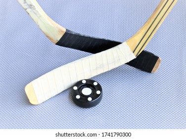 Inline Hockey Puck And Hockey Sticks On Grey Background