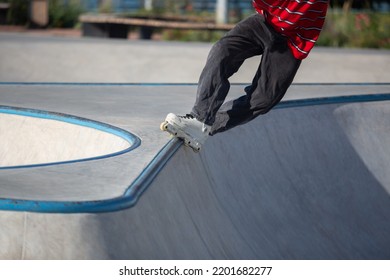 Inline Skater Doing Trick In Concrete Skatepark