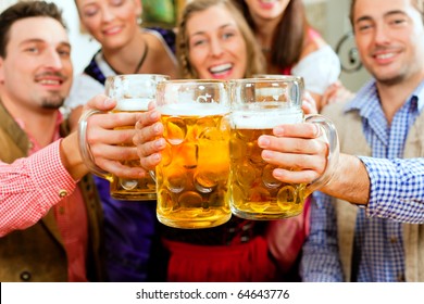 Inn Or Pub In Bavaria - Group Of Five Young Men And Women In Traditional Tracht Drinking Beer And Having A Party With Beer