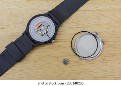 Inner parts of a wrist watch on a wooden table