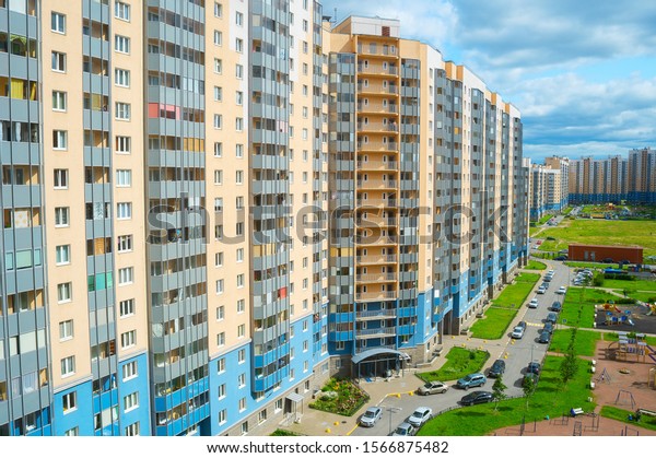 Inner yard among modern apartment buildings\
in residential district of Saint Petersburg, children playground,\
car parking, view from above,\
Russia