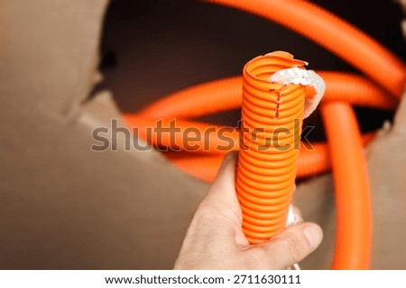 Innerduct conduit with pull string held by electrician or female technician. Conduit system used for cable management, cable pulling for fiber optics or internet upgrades. Selective focus.