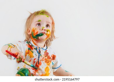 The innocent look of a child who randomly painted his face and clothes with paint. Children's pranks.