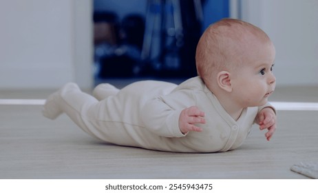 Innocent and playful, baby in a beige bodysuit lifting their head and gazing curiously. Baby crawling on the floor in a bright room - Powered by Shutterstock