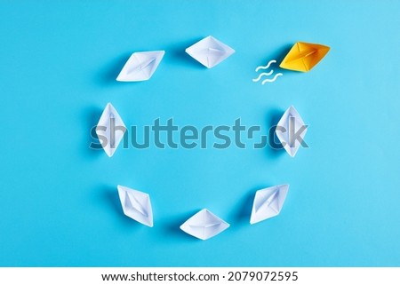 Innovation, difference, creativity or improvisation in business concept. White paper boats going in circle with one boat breaks the routine circle. 