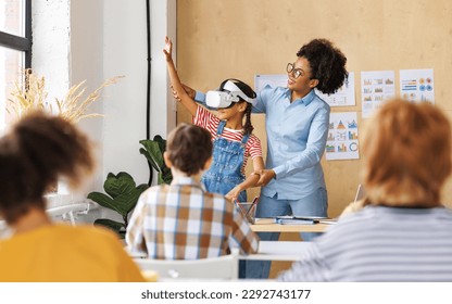 Innovation in education. Student schoolgirl  in virtual reality glasses together with teacher during lesson in bright classroom at school
 - Powered by Shutterstock - Get 15% off with code: PIKWIZARD15