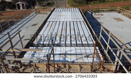 An innovative construction site using lightweight polystyrene foam panels. White polystyrene foam panels are installed in a steel-reinforced frame and prepared for concrete pouring.