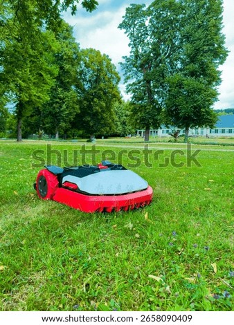 An innovative robotic lawn mower is efficiently maintaining a vibrant green lawn, beautifully surrounded by lush trees, showcasing cuttingedge advanced gardening technology